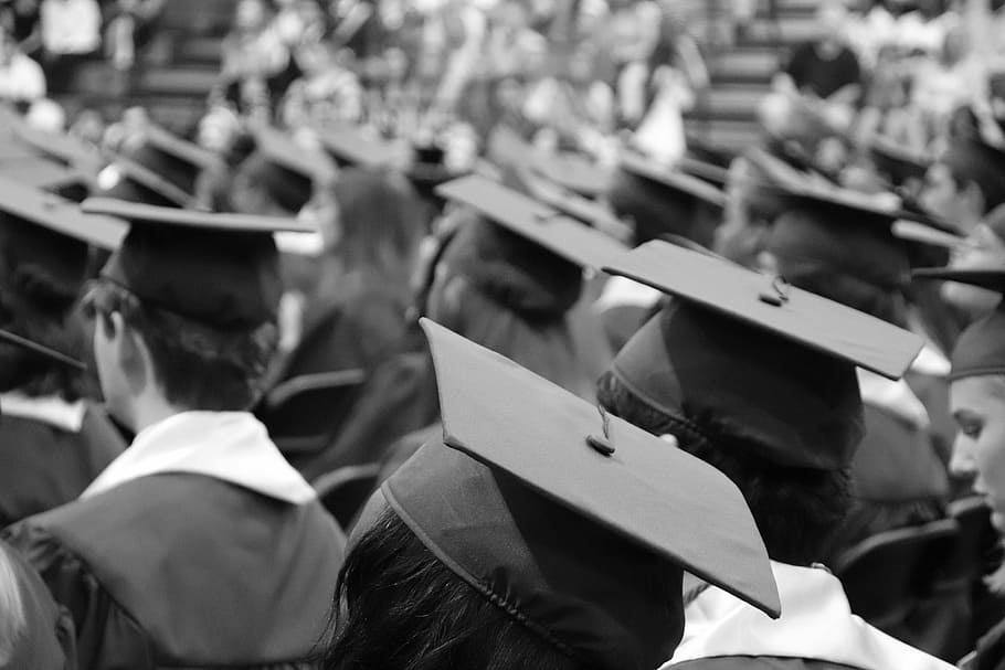 grayscale photo of student wearing academic gowns, graduation cap