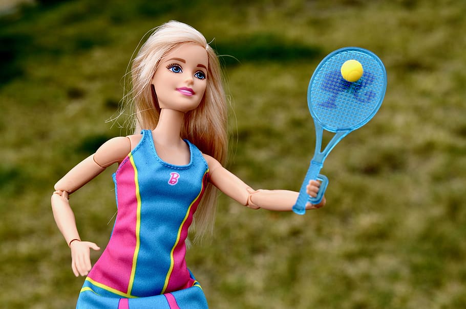 Barbie in pink and blue tank top holding blue tennis racket, doll