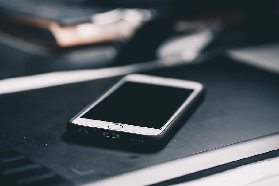 iPhone with black case on black wooden surface, silver iPhone 6 on black table HD wallpaper