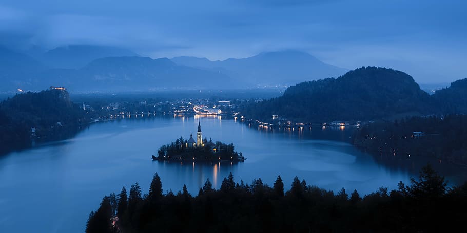 light tower surrounded by body of water during nighttime, landscape HD wallpaper