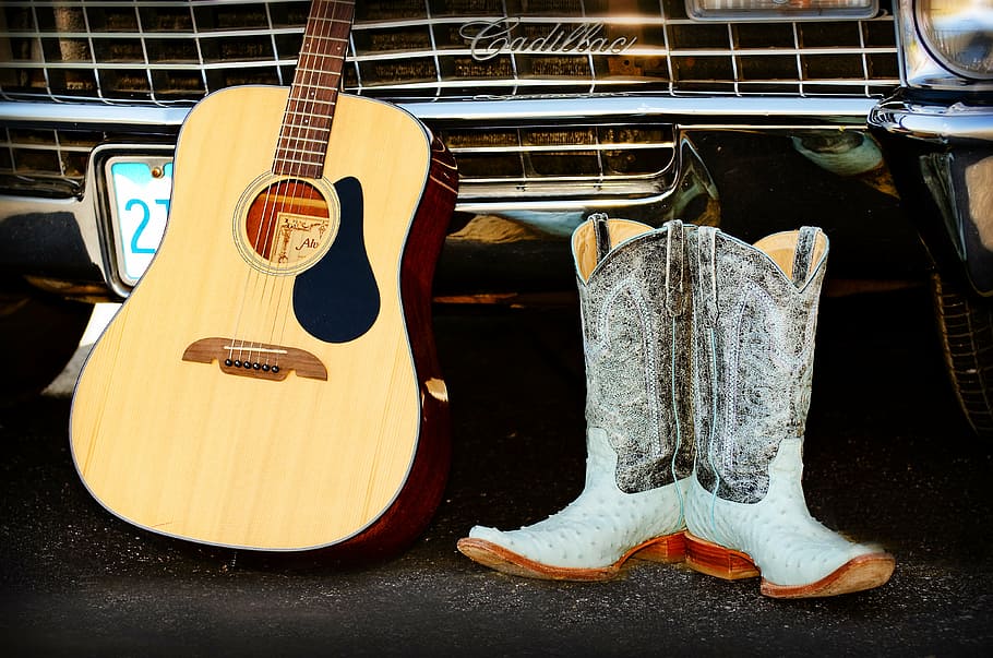 brown dreadnought acoustic guitar beside pair of cowboy boots, HD wallpaper