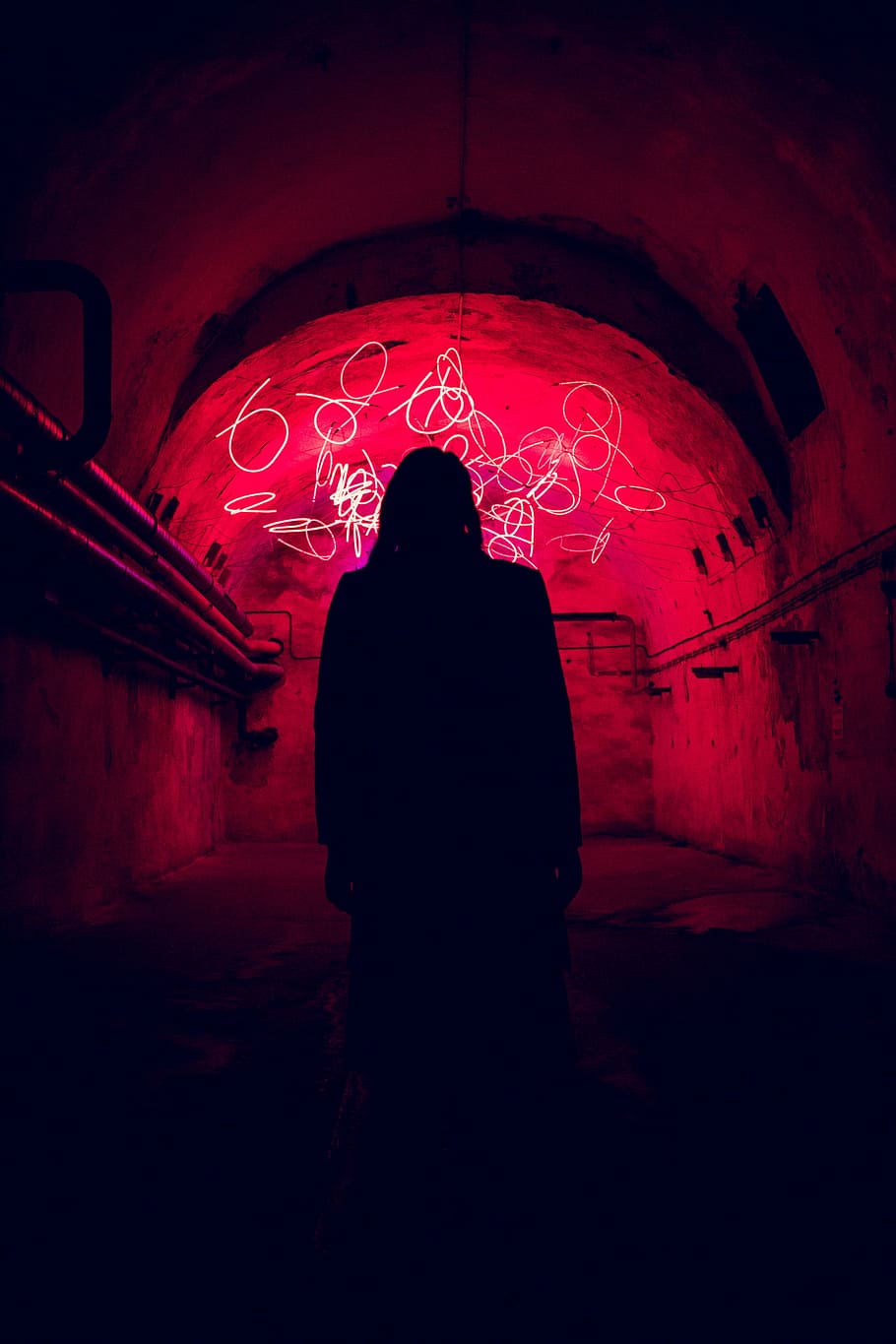 In front of chaos, silhouette of person standing inside tunnel