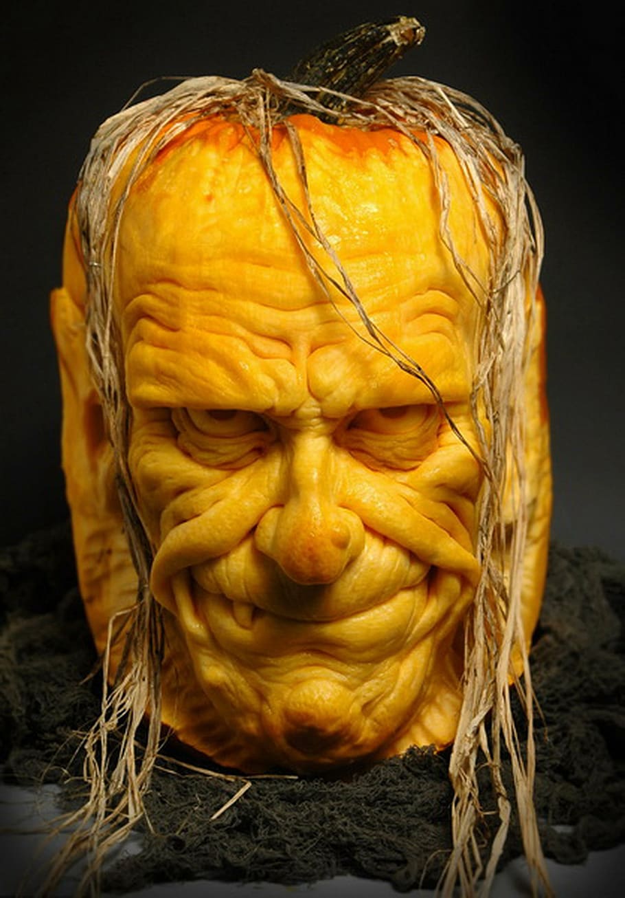 man's face carved pumpkin on black floor, sculpted, halloween