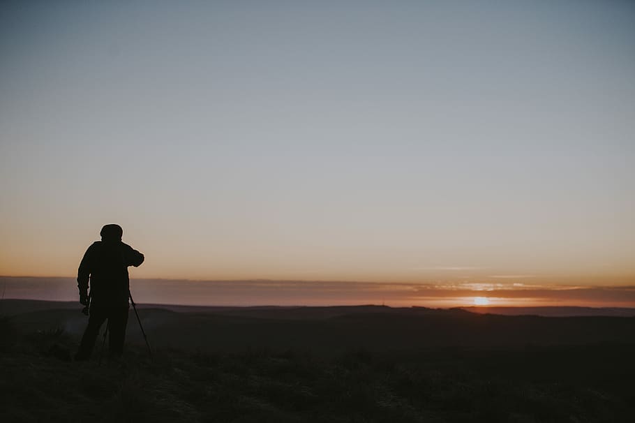 Photographer at sunrise, silhouette of person on shore, sunset HD wallpaper
