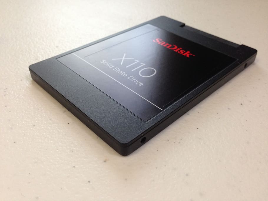 black SanDisk X110 solid state drive on top of white countertop