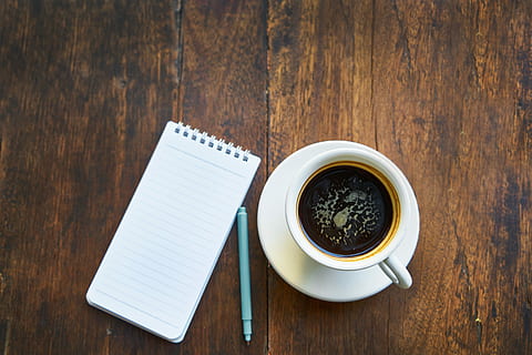 cup of coffee on saucer beside notebook and pen, note book HD wallpaper
