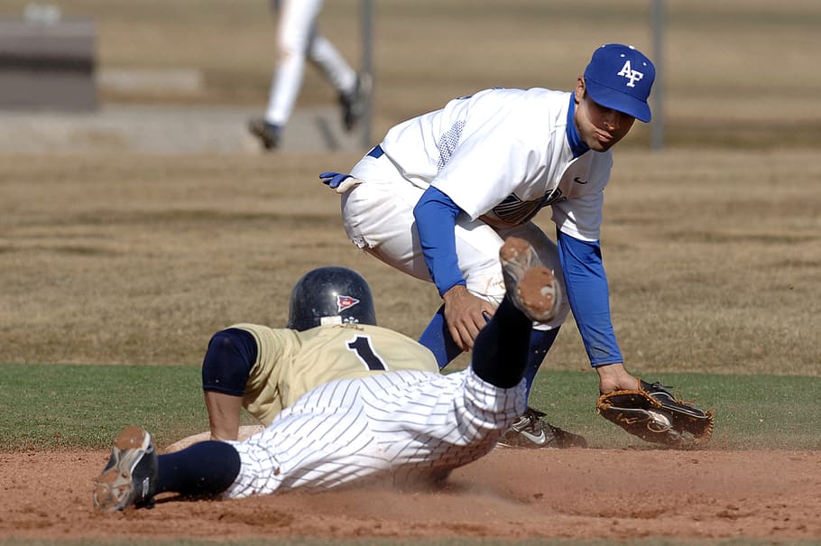 baseball player sliding to base plate beside another baseball player HD wallpaper