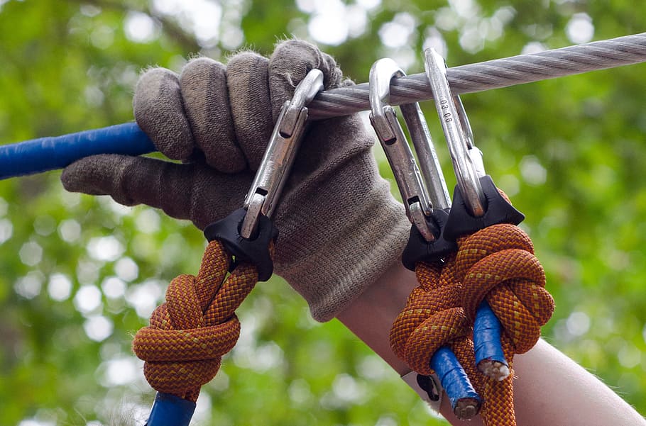 Person in Gray and Beige Gloves Holding on Gray Cable Wire, carabiners