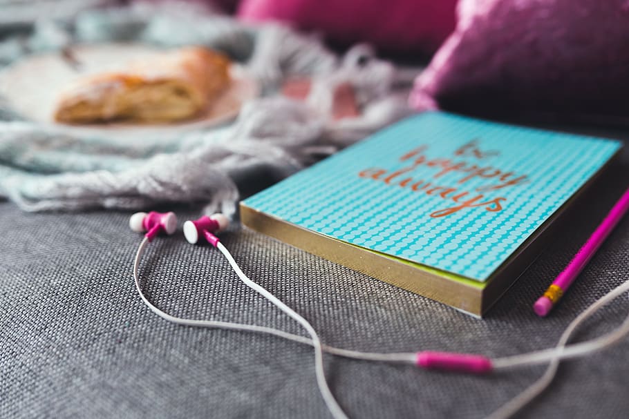 White and Pink Earphones on Gray Textile, blur, book, close-up HD wallpaper