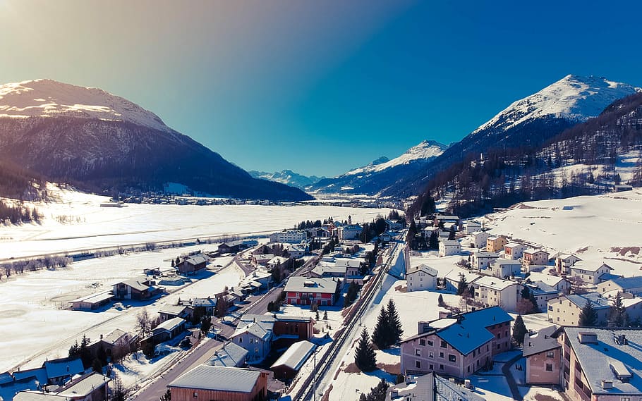 aerial photography of houses covered with snow under blue sky, houses near mountain at daytime HD wallpaper
