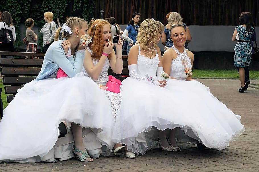 four women in dresses sitting on bench, brides, waiting, wedding