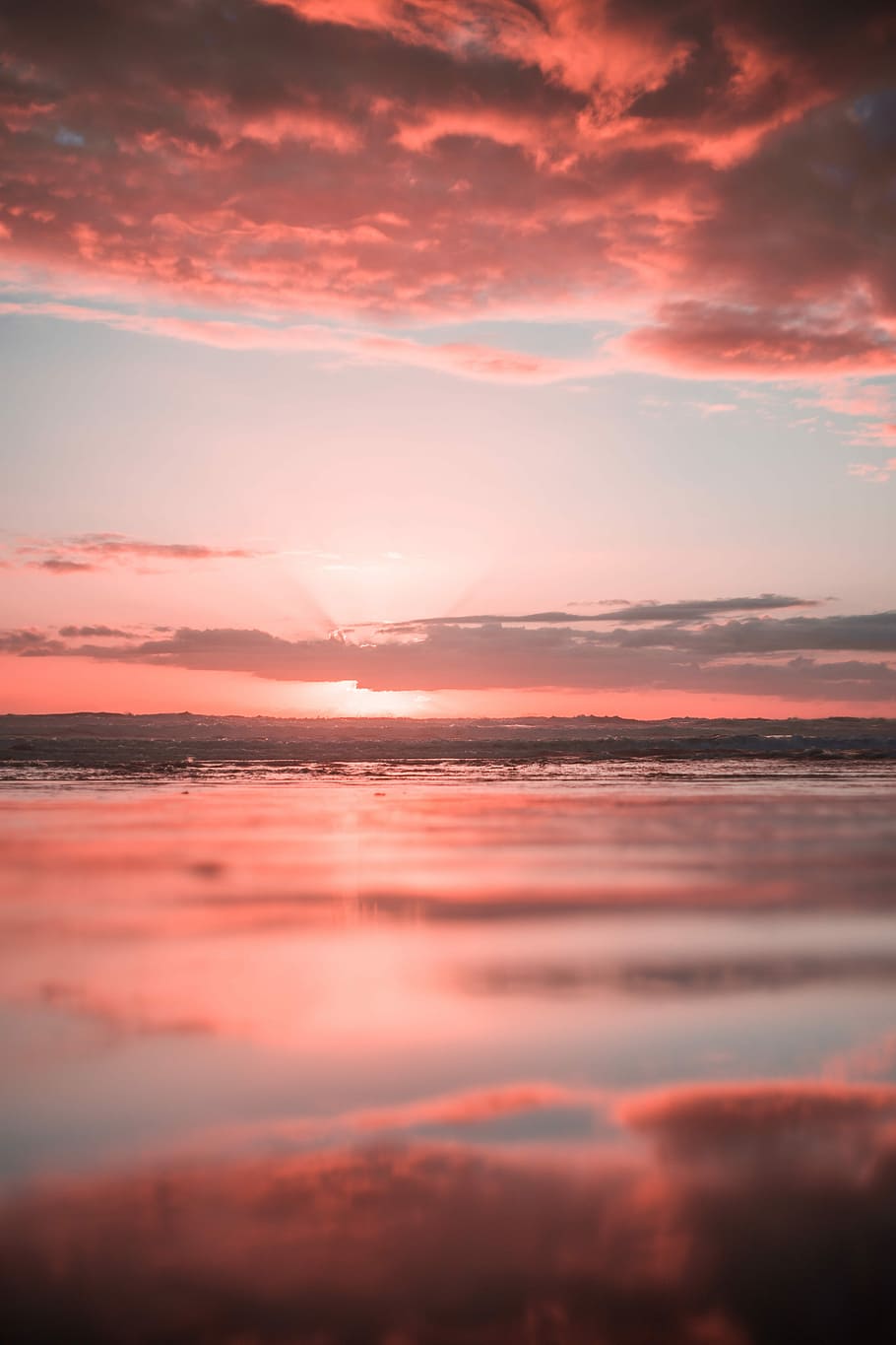 body of water under white clouds during golden hour, ocean water during pink sunset