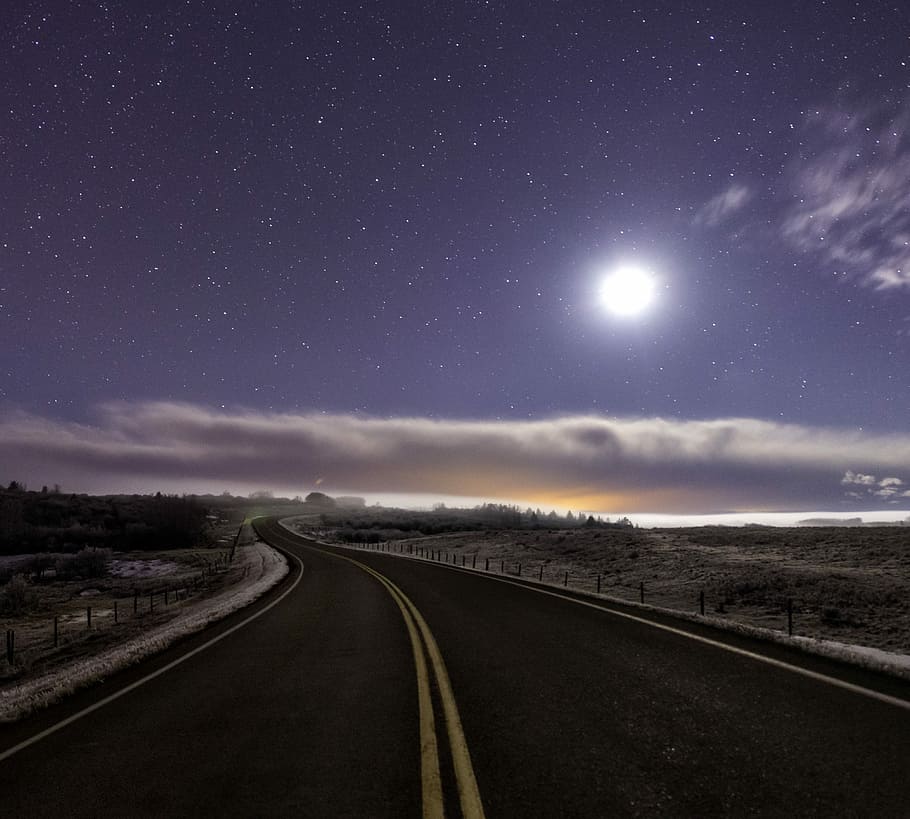concrete road surrounded by grass field, highway leading to dessert during nighttime HD wallpaper