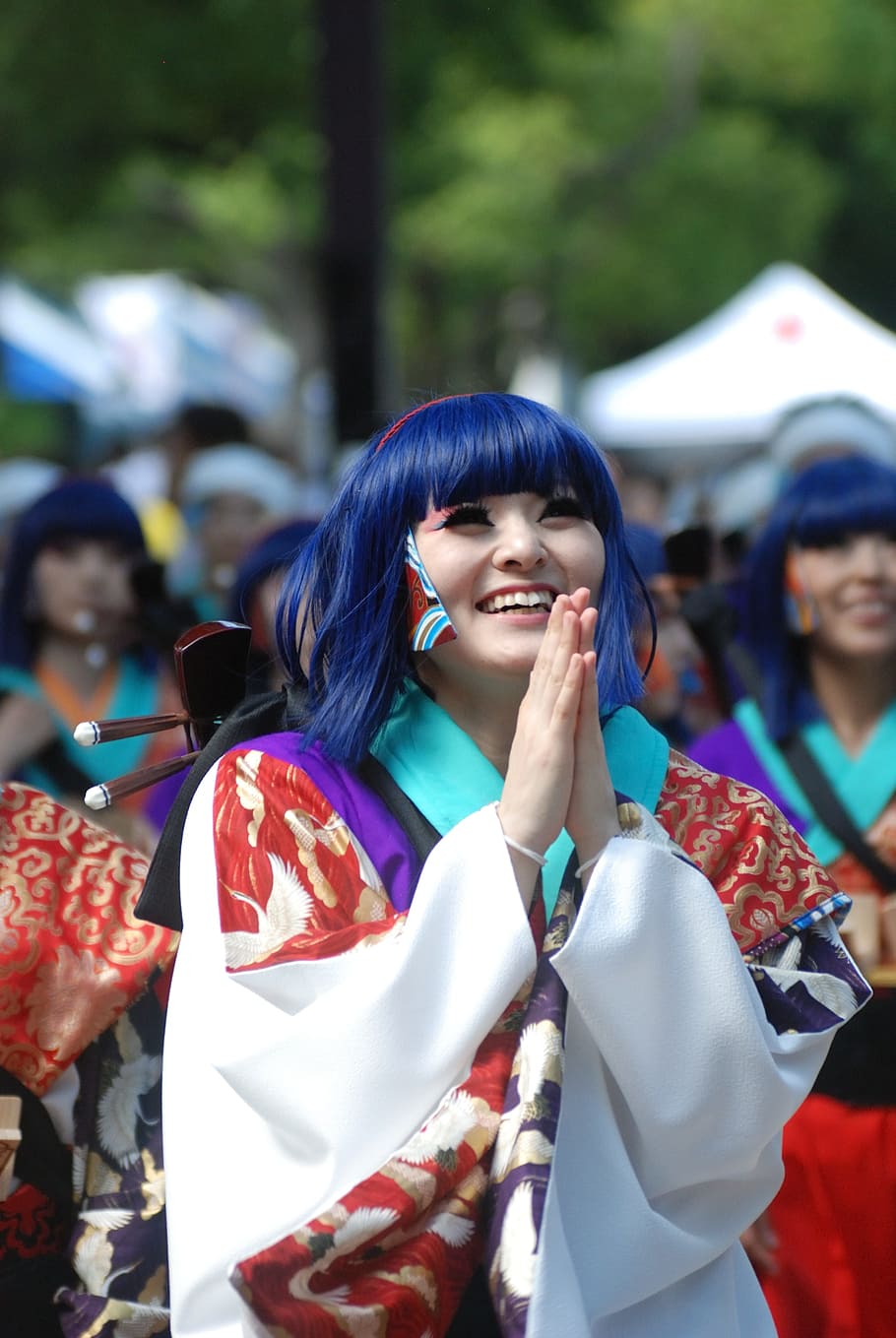woman wearing red, white, and green long-sleeved dress with praying hands smiling HD wallpaper