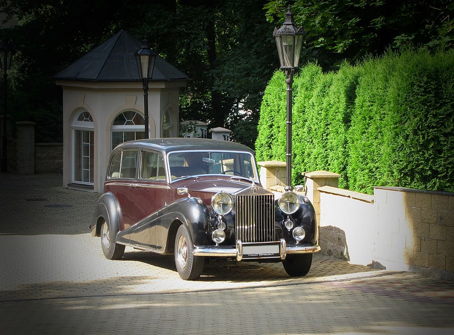 classic black and brown hardtop car parked beside wall during daytime HD wallpaper