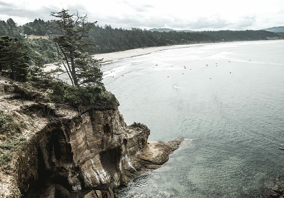 aerial photography of mountain cliff near sea, body of water near brown mountain HD wallpaper
