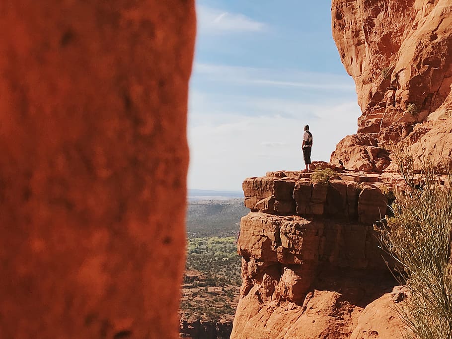person standing on a cliff, brown, shirt, looking, ground, level HD wallpaper