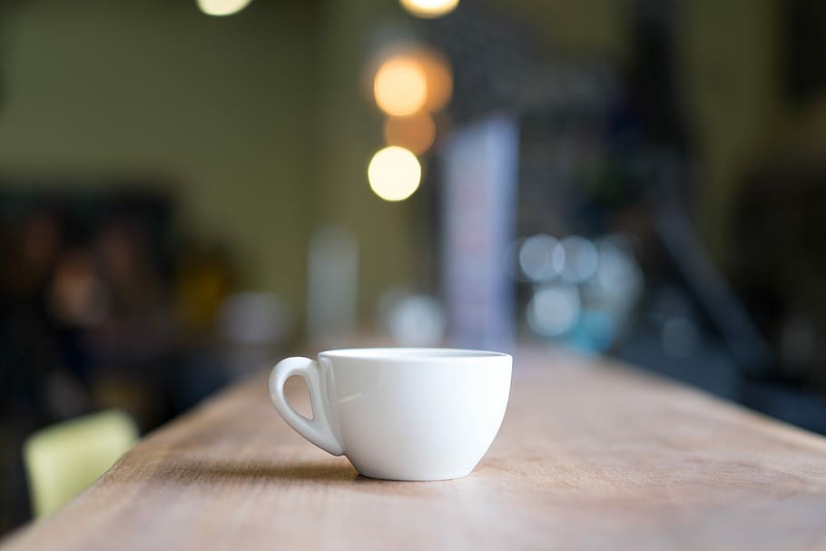 bokeh photography of white mug on brown table, selective focus photograph of white ceramic teacup on wooden surface, HD wallpaper