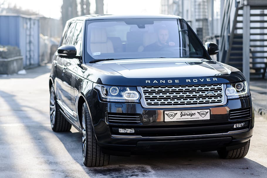 black Land Rover Range Rover SUV running on road during daytime