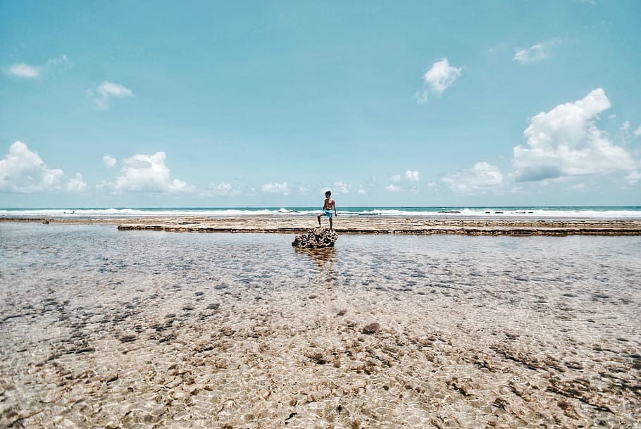 person standing on rock surrounded by body of water, man standing beside body of wate r HD wallpaper