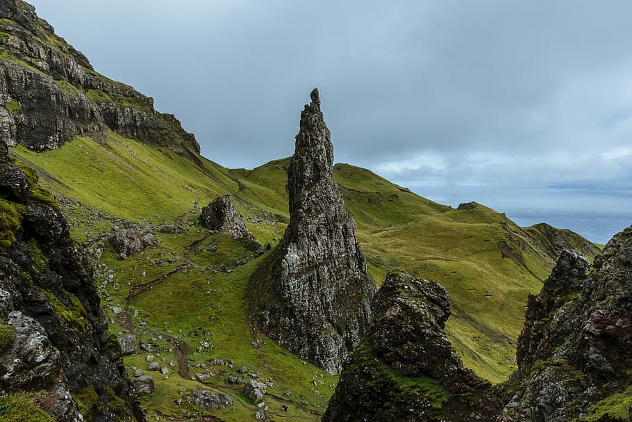 gray mountains surrounded by grass field, black stone formations on green hill HD wallpaper