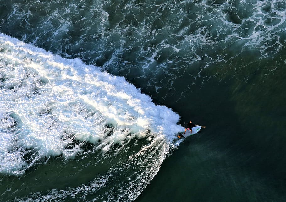 top view photography of man beside surfboard, aerial photography of man waveboarding HD wallpaper