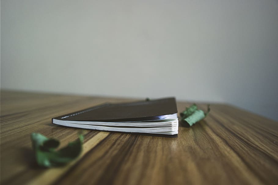 book on wooden surface, black, notepad, notebook, blur, table HD wallpaper