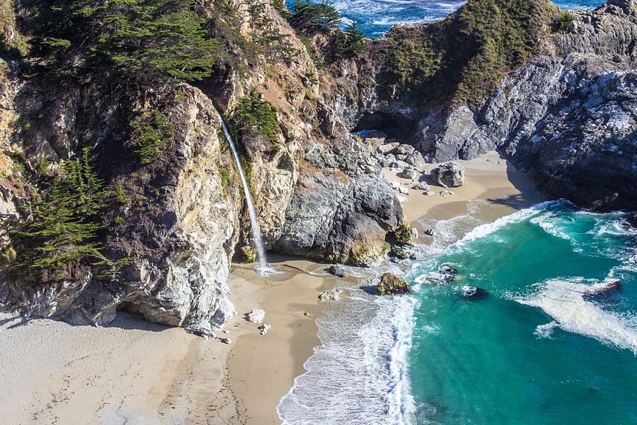 aerial photography of brown cliff and seashore during daytime HD wallpaper