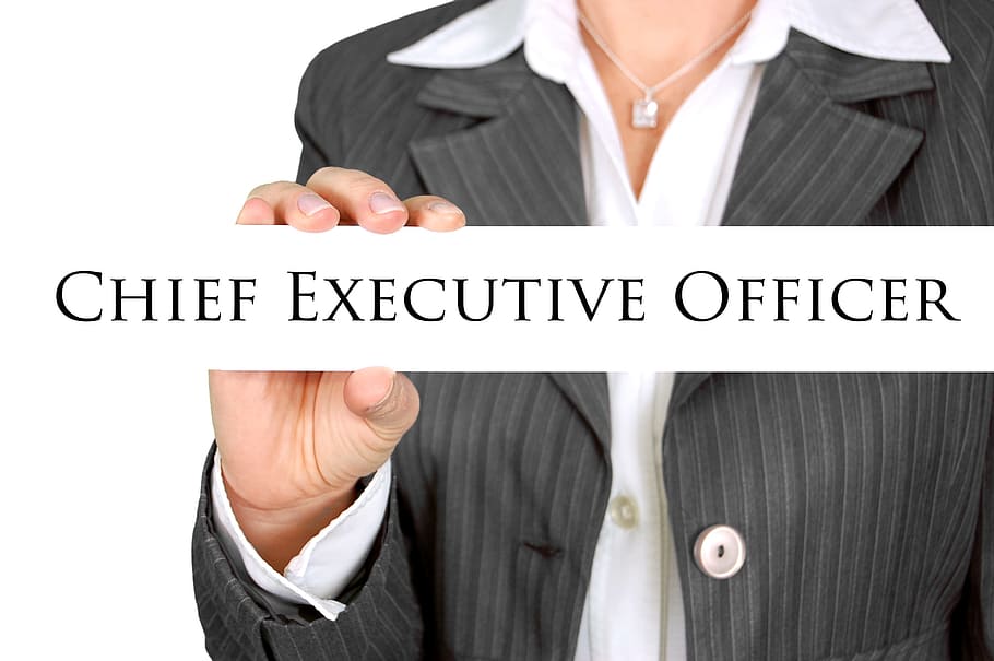 woman in black and grey blazer holding Chief Executive officer sign