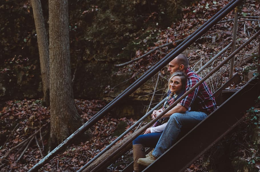 man in blue denim pants hugging woman on staircase during day time, woman and man sitting on stairs hugging HD wallpaper