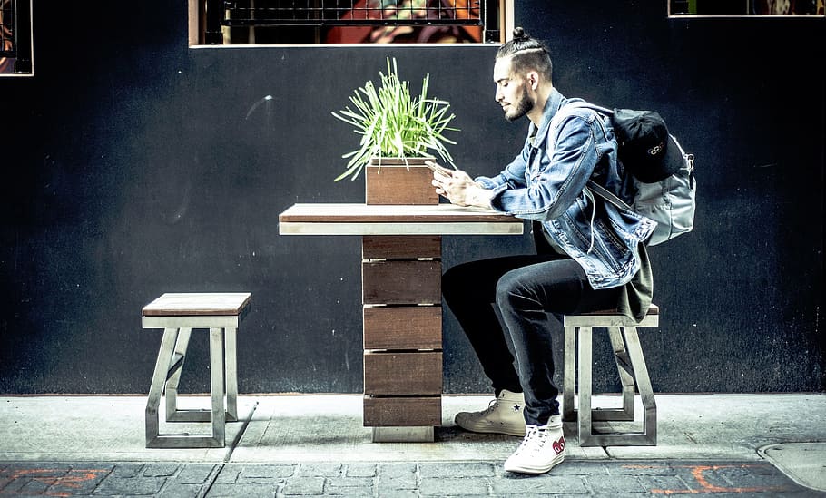 man sitting on brown chair in front of table, people, guy, millenials HD wallpaper