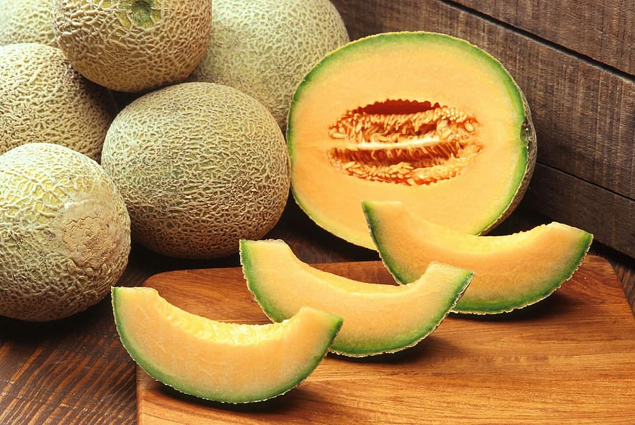 photo of sliced melon on brown chopping board, muskmelons, cantaloupes