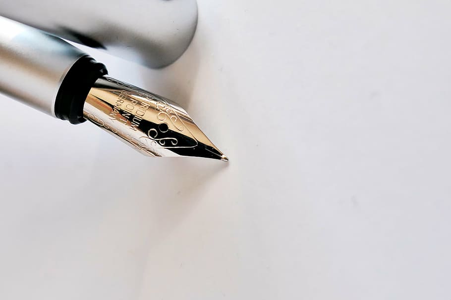 close up image of silver fountain pen, filler, writing implement