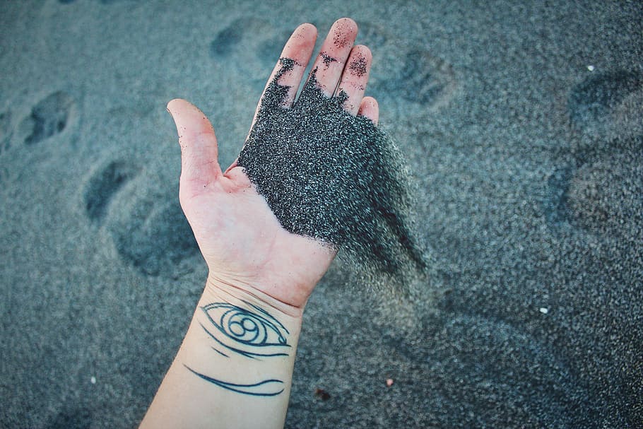 person holding gray sand, hand, black, volcanic, tattoo, human body part HD wallpaper