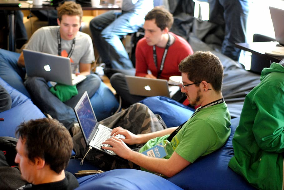 man sitting on blue bean bag usinglaptop, men using their Macbooks HD wallpaper