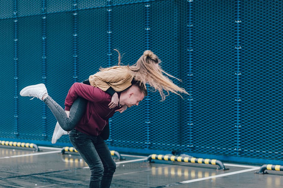 man carrying woman on back, woman piggy bag riding on man during daytime HD wallpaper