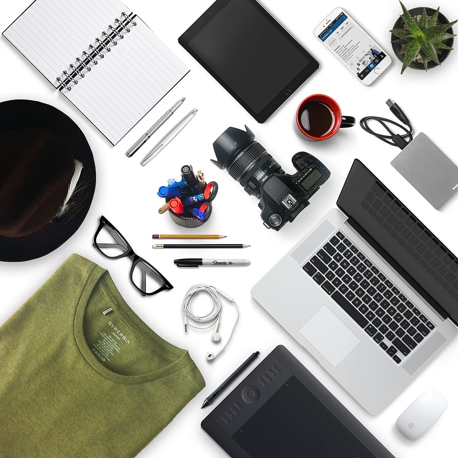 black DSLR camera on top of white surface beside opened laptop HD wallpaper