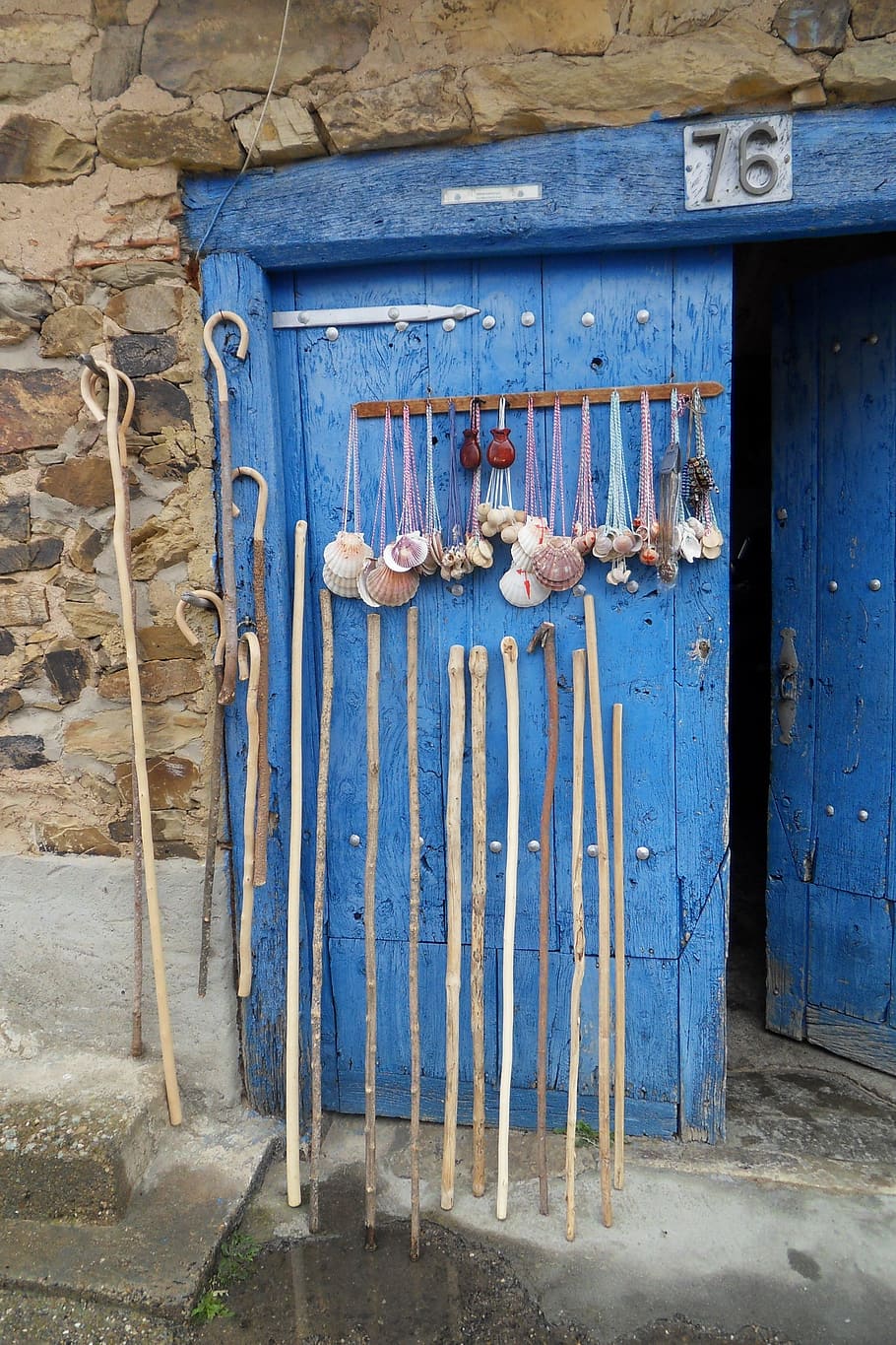 hand canes leaned on blue door, pilgrim, pilgrim rods, jakobsweg