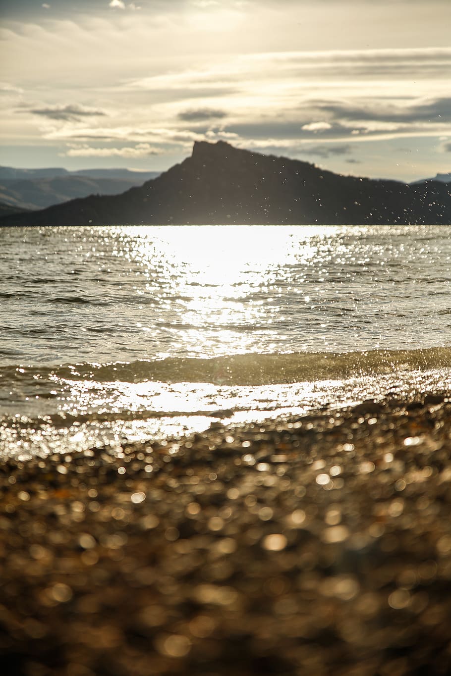 silhouette on mountain near body of water during faytime, body of water across mountain during daytime HD wallpaper