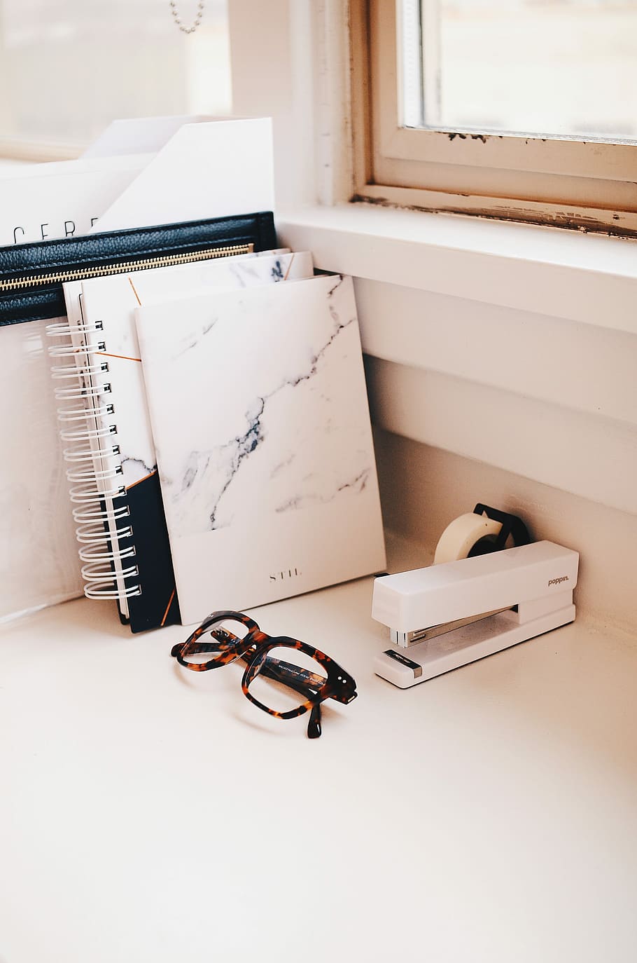 white stapler and eyeglasses with brown tortoiseshell frame on desk, white stapler; notebook; and sunglasses with black and brown frames HD wallpaper