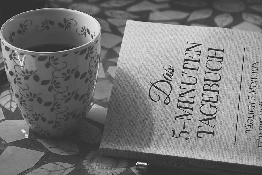 grayscale photography of white ceramic mug near novel book HD wallpaper