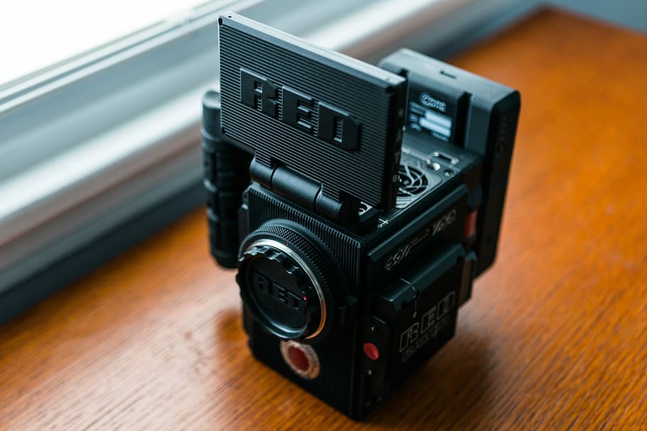 black media player on brown panel, black Red brand camera, video camera HD wallpaper
