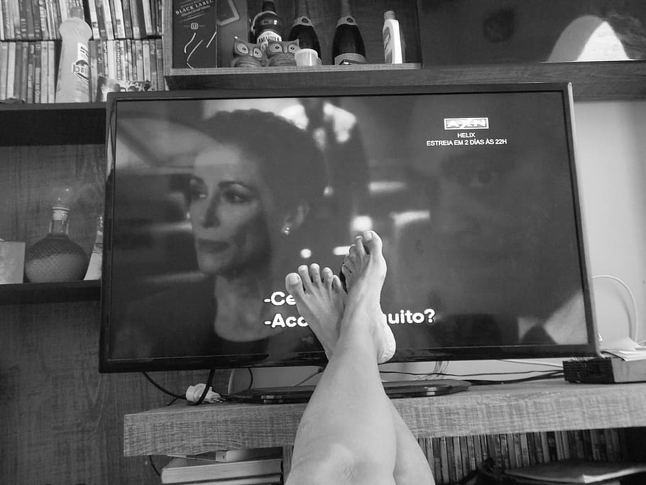 grayscale photo of person's feet in front of flat screen TV HD wallpaper