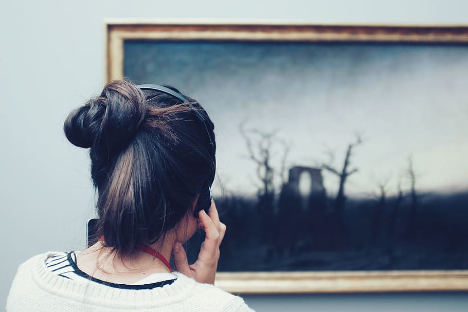 woman looking at a painting using headphones, woman facing on tree painting inside the room HD wallpaper