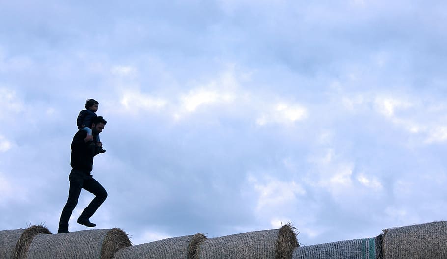 man walking with kid on shoulder during daytime, hay, stack HD wallpaper
