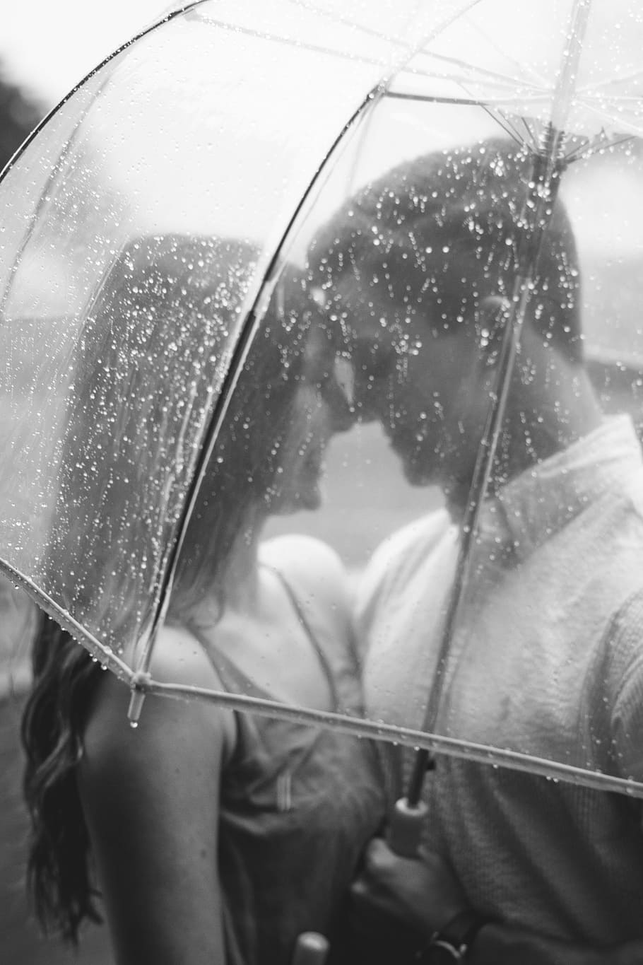 couple under clear umbrella, man and woman standing together under clear umbrella