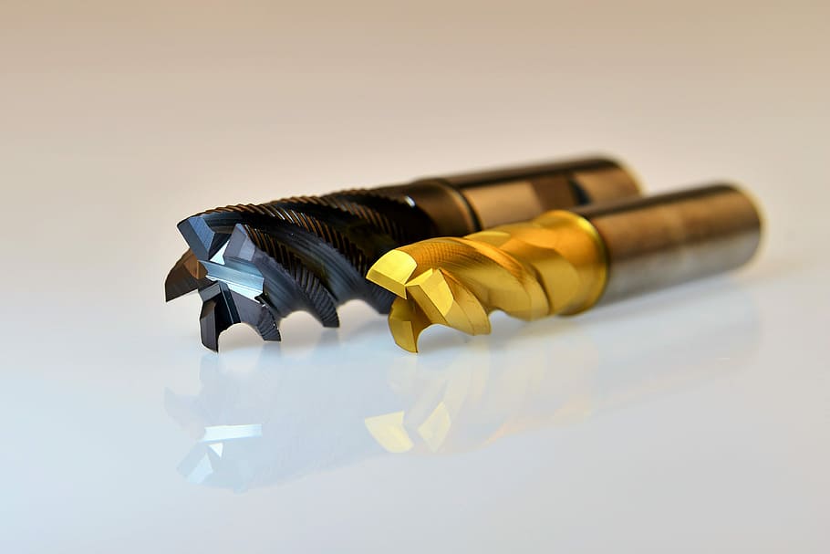 shallow focus photography of black and brown drill bits, milling cutters
