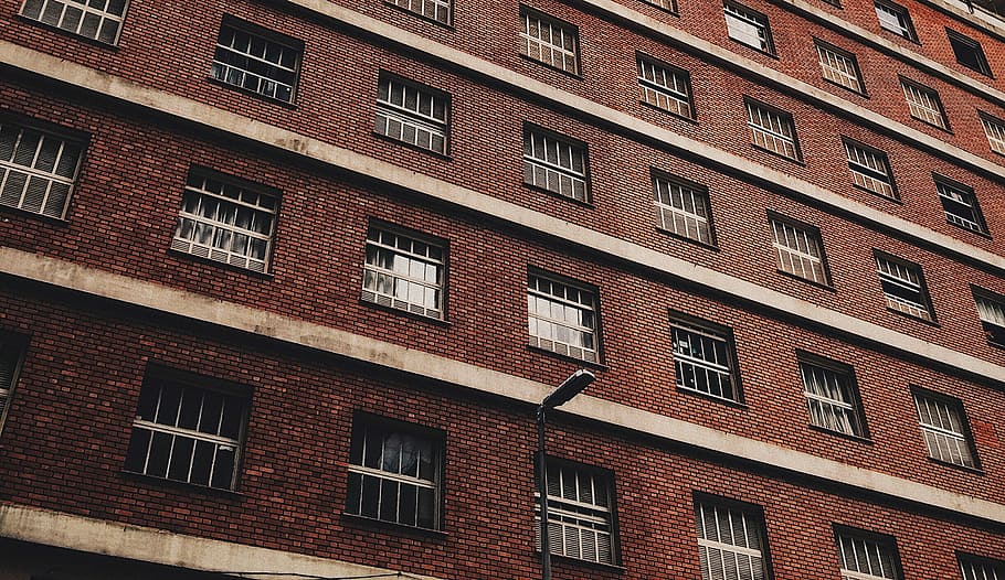 low-angle photography of brown concrete building, low angle photography of brown brick wall building with grill windows HD wallpaper