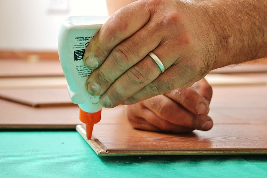 person holding glue plastic bottle, wood glue, work, laminate HD wallpaper