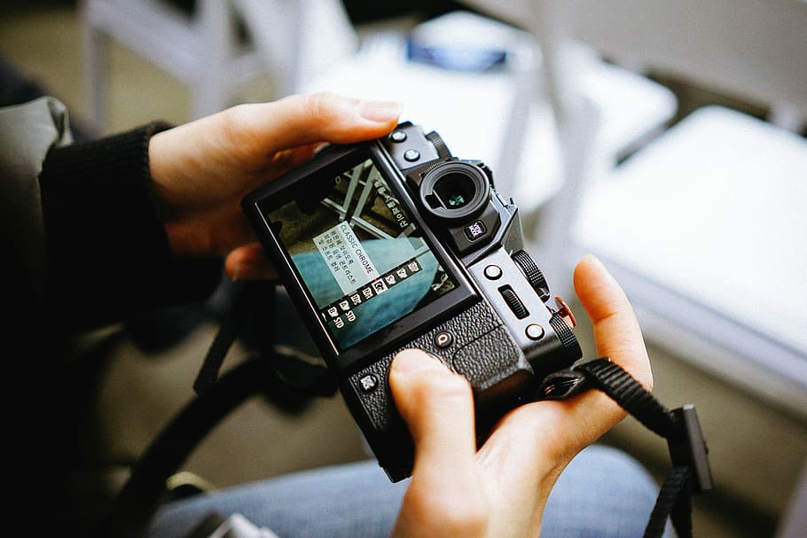 person holding black DSLR camera scanning for settings, selective focus of person holding camera HD wallpaper